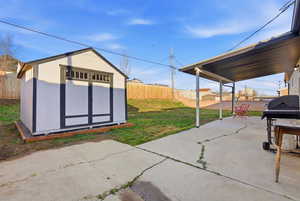 Fenced backyard featuring grilling area, a patio area, and a shed