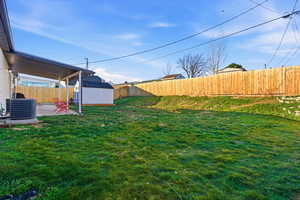 Fenced backyard with a patio area and a shed