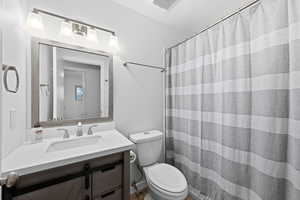 Full bath with a shower with curtain and vanity