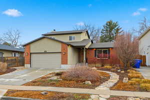 Traditional home with driveway, a garage, brick siding, stucco siding, and roof with shingles