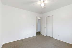 Unfurnished bedroom with carpet, ceiling fan, and a closet