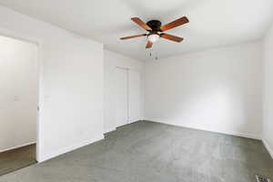 Unfurnished bedroom featuring carpet floors, a ceiling fan, and a closet