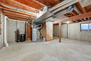 Unfinished basement with stairway and a water softener