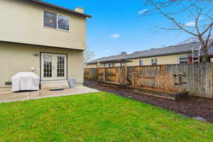 Fenced backyard with a patio area and french doors
