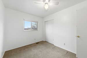 Unfurnished bedroom featuring carpet, a closet, and ceiling fan