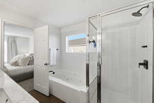 Ensuite bathroom featuring a stall shower, a tub with jets, and vanity