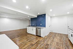 Kitchen with white cabinets, dark wood-style flooring, dishwasher, recessed lighting, and open floor plan