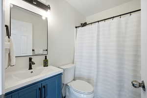 Full bath with a shower with shower curtain and vanity