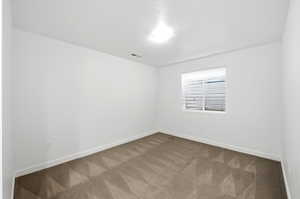 Empty room with carpet and a textured ceiling