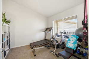 Exercise area featuring carpet floors and vaulted ceiling