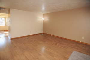 Spare room with a textured ceiling and light wood-type flooring
