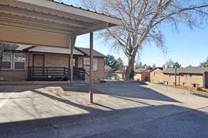 View of front of property featuring brick siding, a parking lot, and a residential view