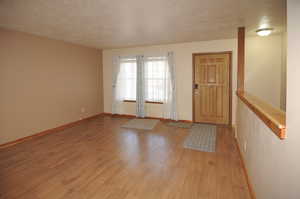 Foyer featuring a textured ceiling and light wood finished floors