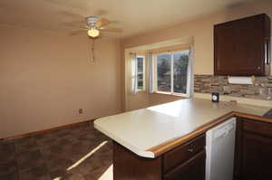 Kitchen with dark brown cabinets, light countertops, dishwasher, tasteful backsplash, and a textured ceiling
