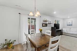 Dining room with light wood finished floors, a chandelier, and recessed lighting