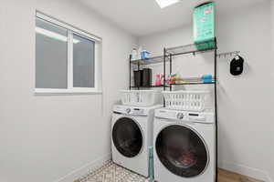 Laundry area with baseboards and washer and clothes dryer