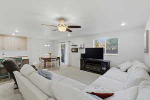 Living area featuring recessed lighting, light wood-type flooring, plenty of natural light, a ceiling fan, and a fireplace