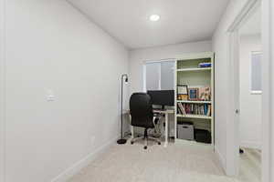 Office space featuring light carpet and baseboards
