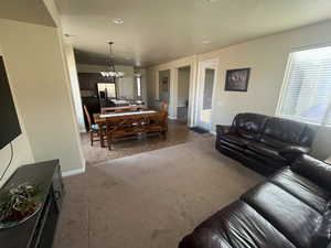 Carpeted living room with a chandelier and tile patterned flooring