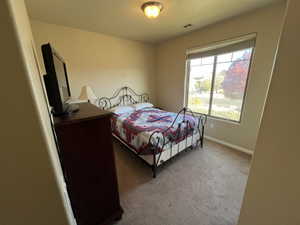Bedroom with light carpet and baseboards