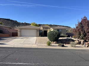 Prairie-style home with concrete driveway, stucco siding, a garage, and a mountain view