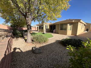 Rear view of house with a fenced backyard, stucco siding, and a patio area