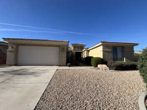 View of front of home featuring stucco siding, concrete driveway, a tiled roof, and a garage