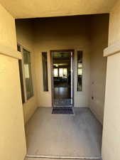 Entrance to property with stucco siding and a patio