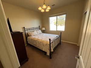 Bedroom with carpet flooring and a chandelier
