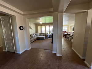 Living room with dark tile patterned floors and a tray ceiling