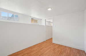 Basement featuring a textured ceiling and wood finished floors