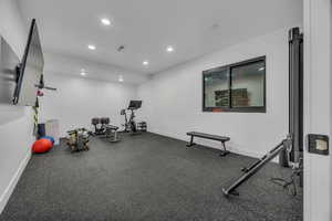 Exercise room with recessed lighting and dark flooring
