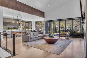 Living area featuring light wood-style flooring, a high ceiling, and recessed lighting