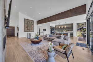Living room featuring light wood-type flooring, lofted ceiling, and recessed lighting