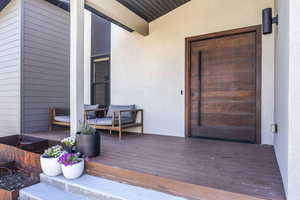Entrance to property featuring stucco siding and a deck