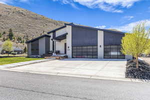 Contemporary home featuring stucco siding, concrete driveway, a garage, and covered porch