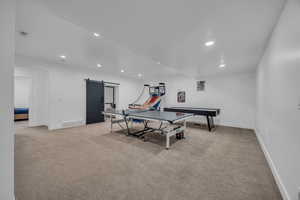 Playroom featuring recessed lighting, a barn door, and light colored carpet