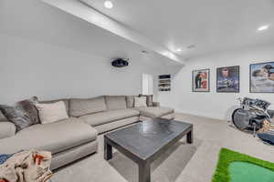 Living area with light carpet and recessed lighting