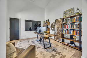 Home office featuring high vaulted ceiling and light wood finished floors