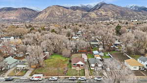 Aerial view of property and surrounding area with nearby suburban area and mountains