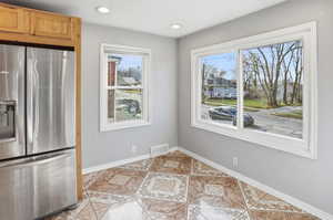 Dining area with light tile patterned floors and recessed lighting