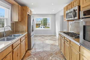 Kitchen featuring tasteful backsplash, stainless steel appliances, tile counters, recessed lighting, and light tile patterned floors