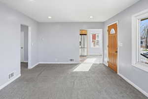 Entryway with light carpet and recessed lighting