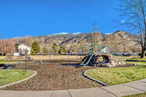 View of play area with a mountain view and a lawn