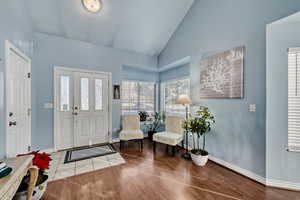 Foyer entrance featuring wood finished floors and high vaulted ceiling