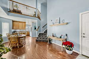 Dining area featuring stairs, light wood-type flooring, and a high ceiling