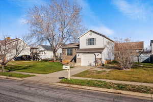 View of front of home with concrete driveway, an attached garage, and brick siding