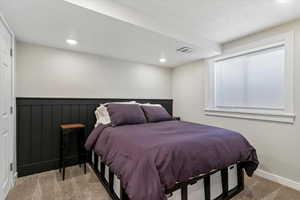 Bedroom with carpet, wainscoting, and recessed lighting