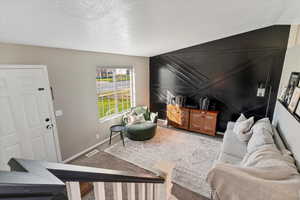 Living room with a textured ceiling and carpet floors