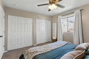 Bedroom with carpet flooring, multiple closets, and a ceiling fan
